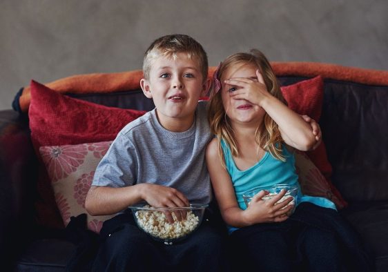 kids-watching-movie.jpg To barn ser på barnefilm mens de spiser popcorn